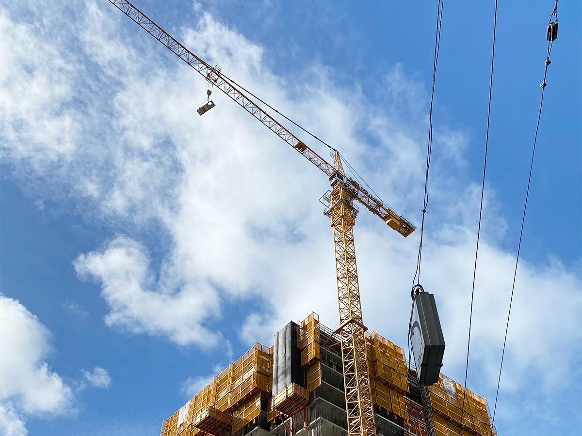 Construction crane against a blue sky with white clouds