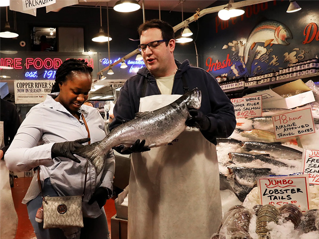 Man holding fish at Pike Place Market