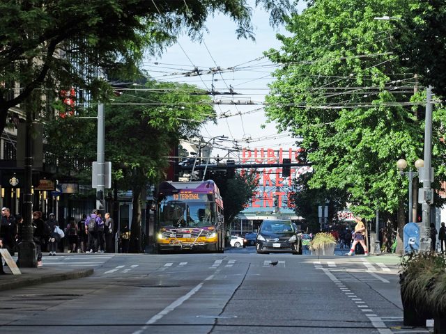 Bus, cars and pedestrians on Pike-Pine in downtown Seattle on a sunny day