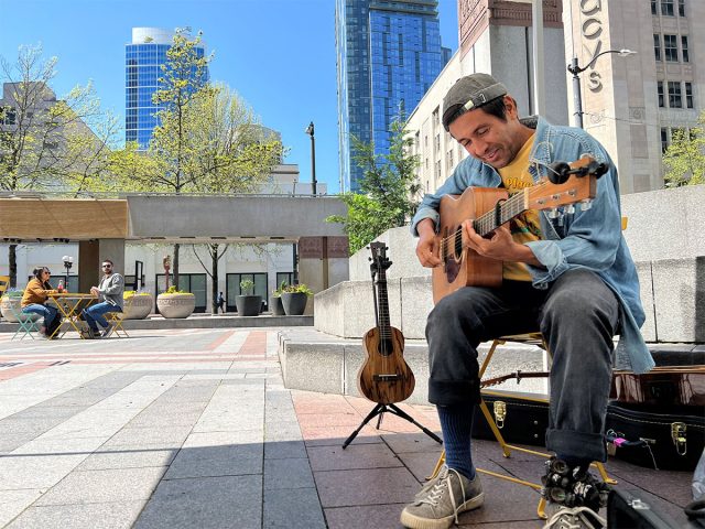 Live music at Westlake Park on a sunny day in downtown Seattle. Musician Drew Martin on guitar.