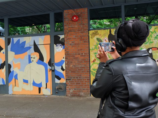 Woman photographing a mural