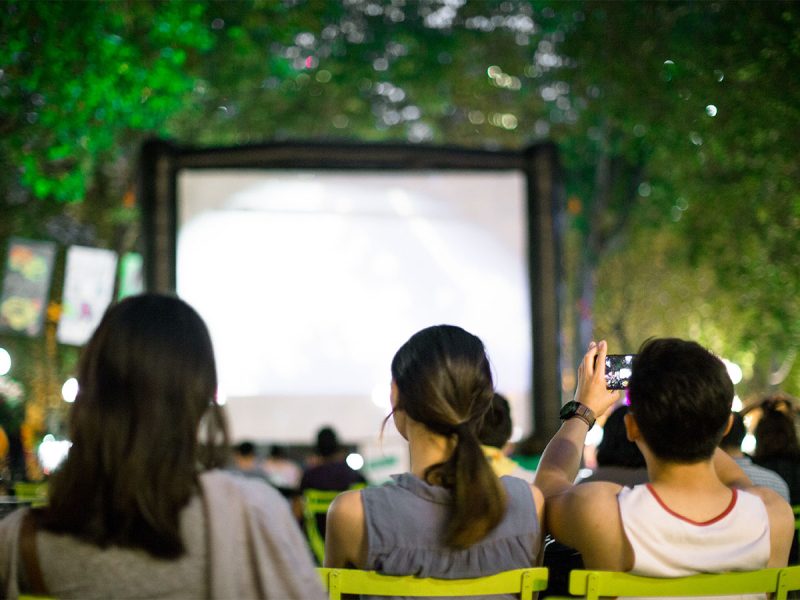 Young people watching a movie in Occidental Square at night