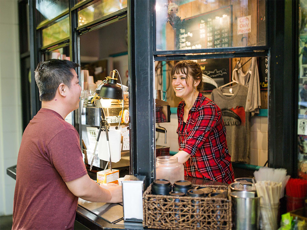 Customer ordering coffee with smiling barista