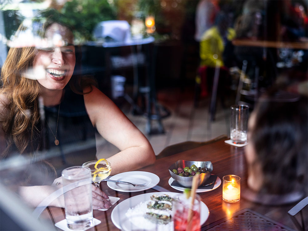 Woman smiling and enjoying food and drinks