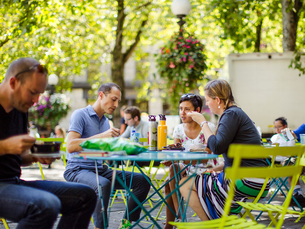 People eating lunch at a park table