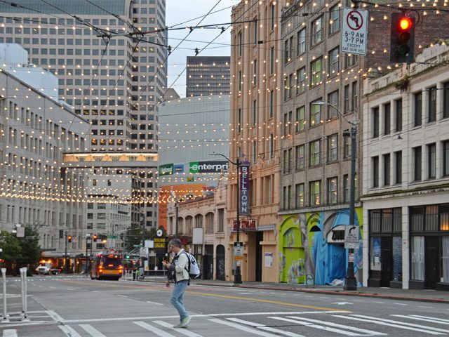 New murals on buildings and lights strung across Third Avenue in downtown Seattle.