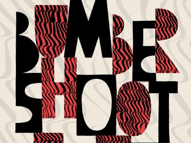 Bumbershoot: Red and black blocky lettering on a light wavy patterned background