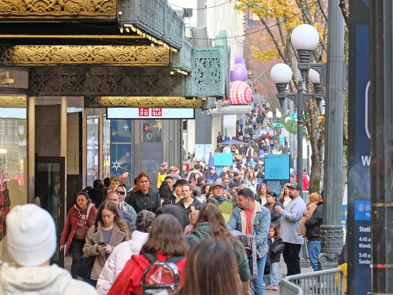 Packed sidewalk — many pedestrians and shoppers on Pine Street in downtown Seattle during the 2025 holiday season