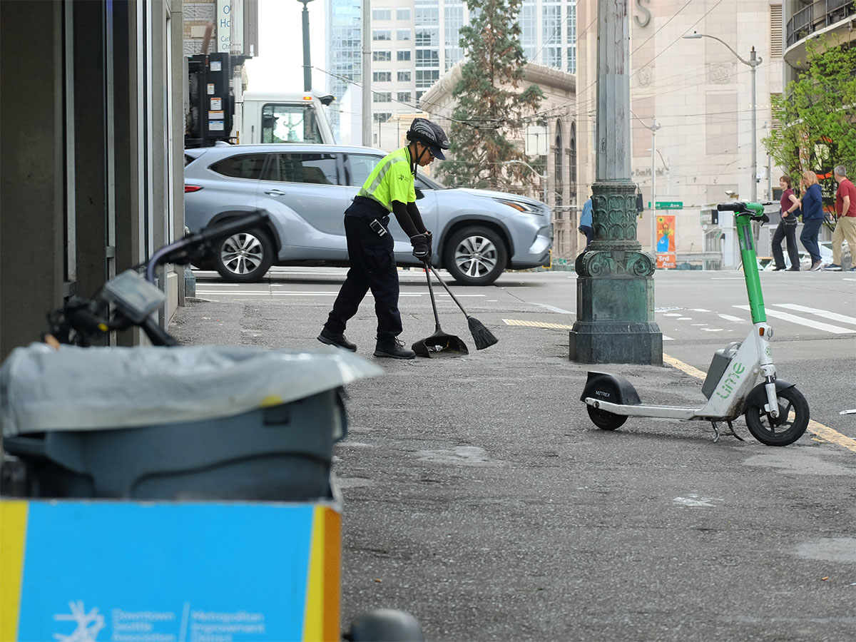 Clean Team ambassador Brittany sweeping a Seattle sidewalk