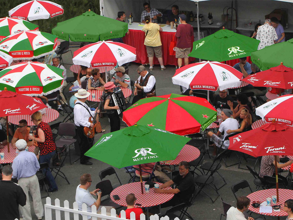 Festa Italiana Seattle - red, green and white umbrellas, people enjoying refreshments at tables