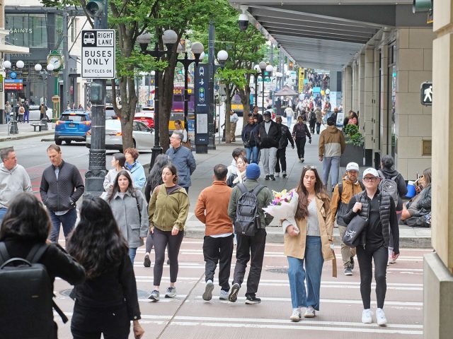People walk along Pine Street near Westlake Park in downtown Seattle.