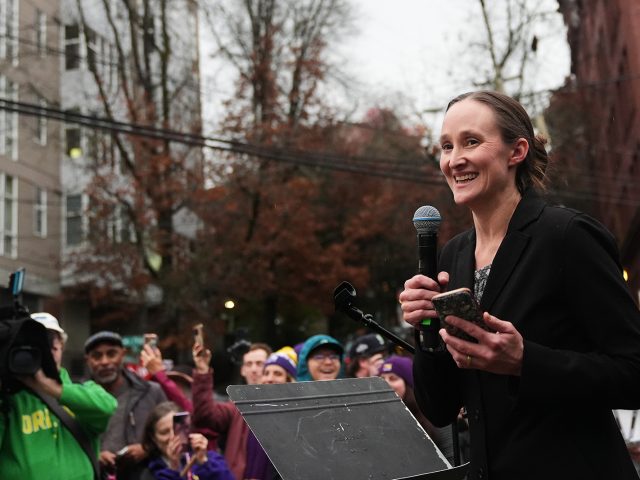 A smiling Seattle Mayor-elect Katie Wilson is pictured speaking at an outdoor protest in 2025. Wilson will take over as mayor in January 2026.